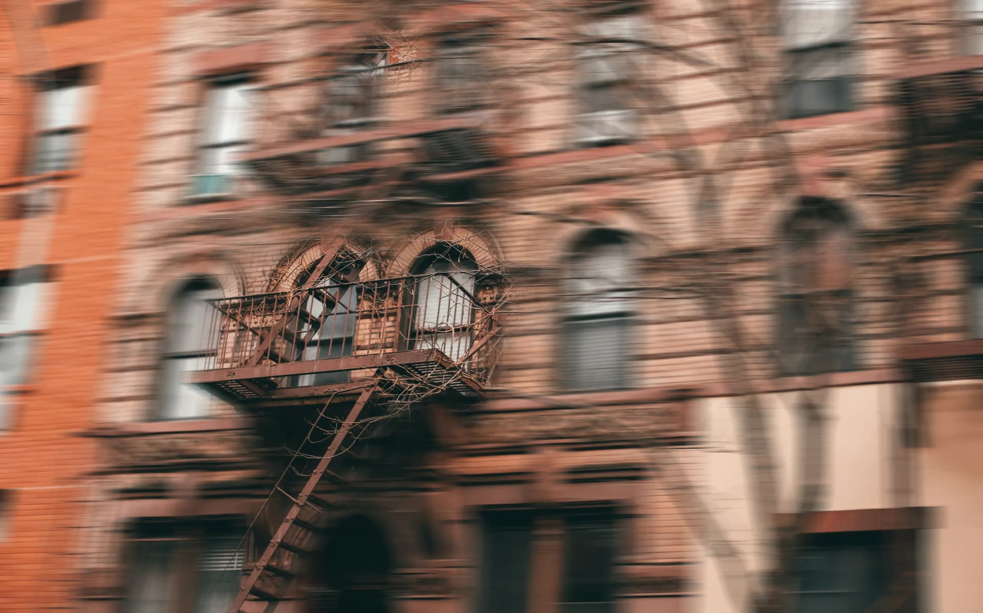A brick building with a fire escape, seen in motion