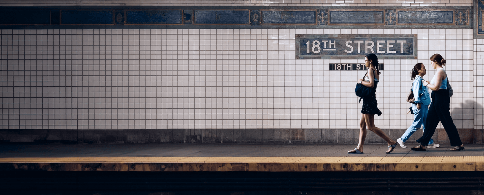 People walking along the 18th Street subway platform